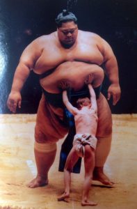Small kid pushing sumo wrestler vs meme template